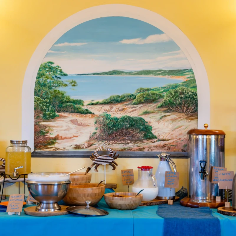 Buffet colazione con vista mare attraverso arco decorativo in sala Hotel Luci del Faro Calasetta